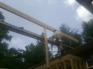 Carpenter setting a ridge beam over a new addition frame — Ice Dam Removal by Roofing Brothers in Hawkeye