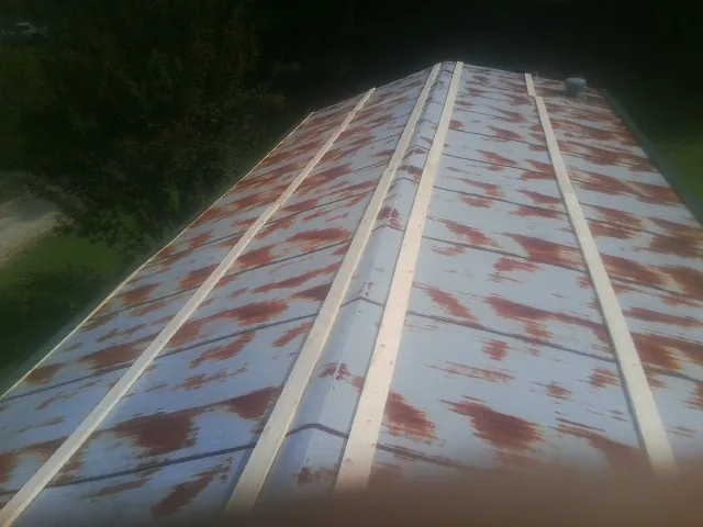 Rusted metal roof panels with new wood purlins before replacement — Storm Damage Roof Repair in Hawkeye by Roofing Brothers