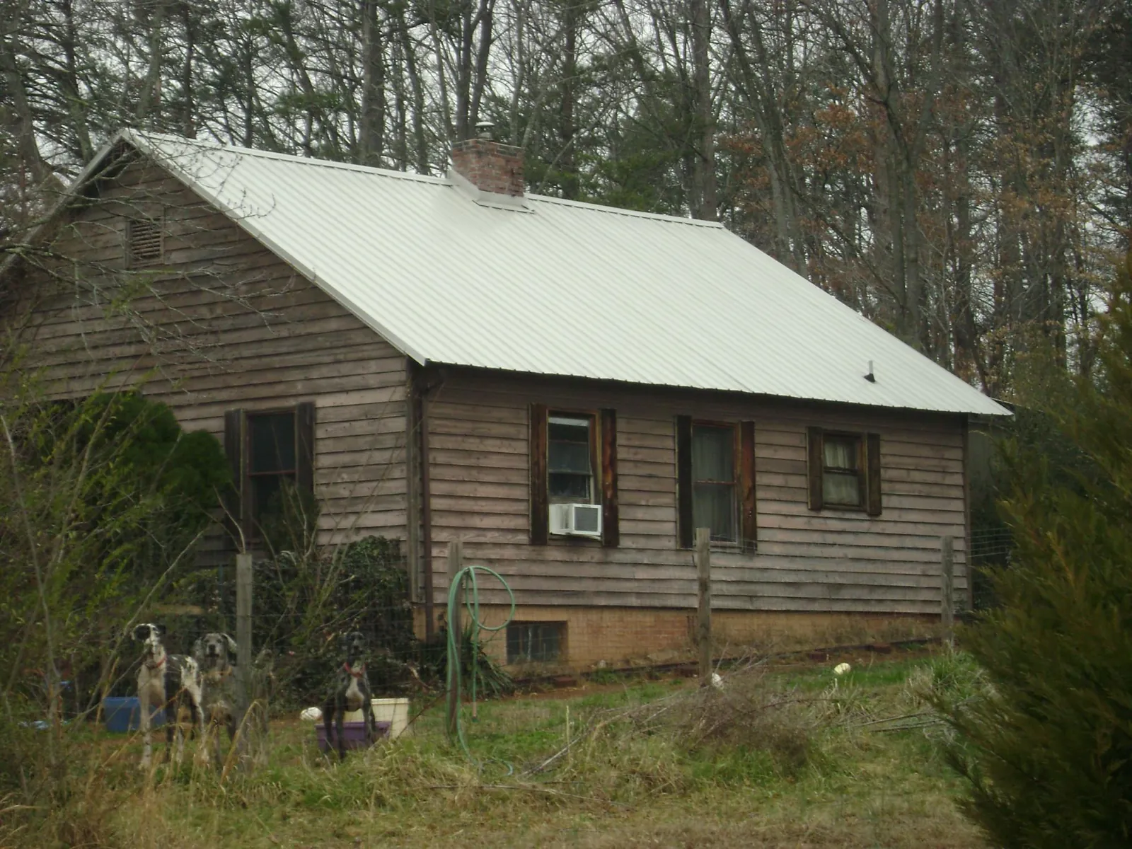 White metal roof on an old wood sided farmhouse, from a Metal Roof Installation job in Hawkeye